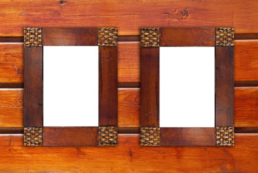Two blank wooden frames on wooden wall.