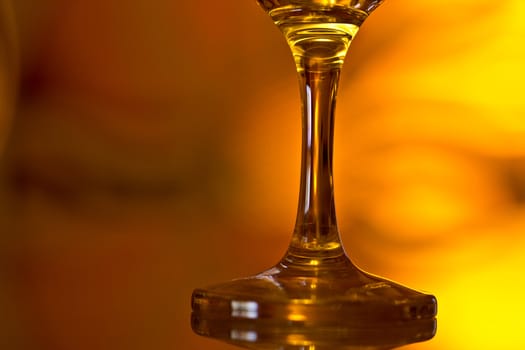 A closeup shot of the base of a wine glass on a moody background