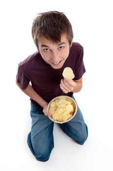 A boy dressed casually and  holding a bowl of crinkle cut potato crisps chips snack and smiling.  White background.