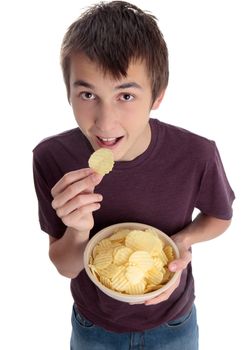 A boy eating crispy potato chips snack and looking up.  White background.