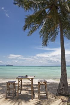 Bamboo table and chairs on a beautiful beach in thailand. Ko phi phi island.