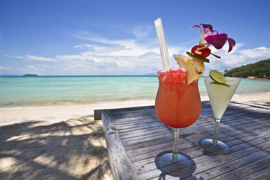 Couple of cocktails with a beautiful beach in the background.