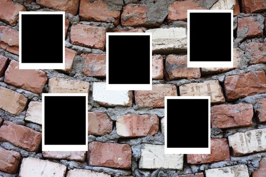 set of five old blank polaroids frames lying on a brick surface 