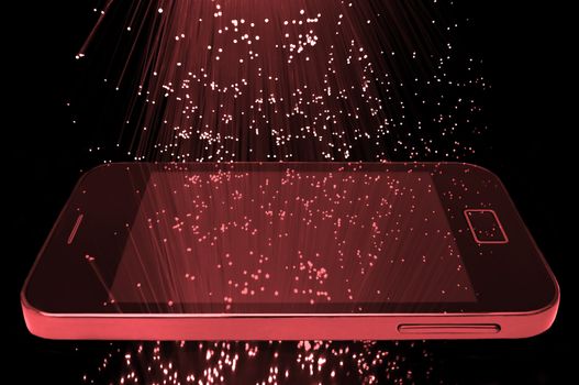 Many illuminated red fiber optic light strands cascading down against a black background and reflecting on the screen of a smart phone in the foreground