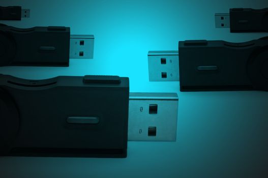 Close and low level capturing portions of several black usb sd adaptors arranged over dark blue light effect