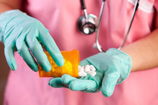 Healthcare worker in gloved hands dispensing prescription drugs