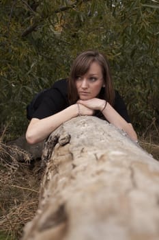 young model posing on a log.