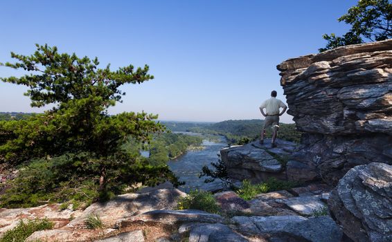 Senior male hiker overlooking the shenandoah and potomac rivers by the town of Harpers Ferry