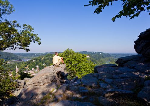 Senior male hiker overlooking the shenandoah and potomac rivers by the town of Harpers Ferry