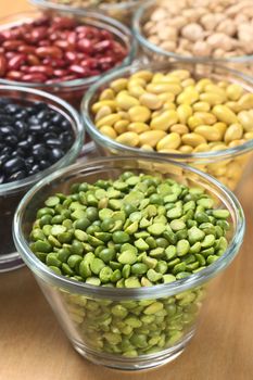 Split peas and other legumes (black beans, canary beans, kidney beans, chickpeas) in glass bowls (Selective Focus, Focus one third into the split peas) 