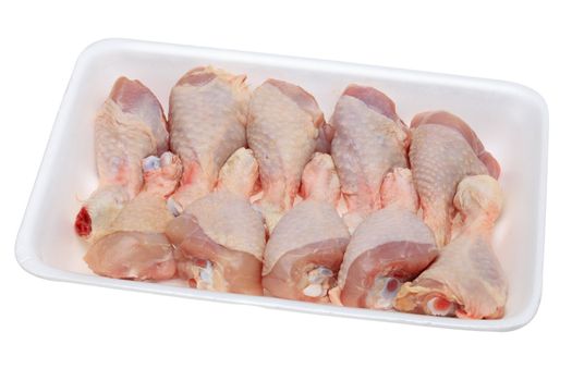 Image of a polystyrene tray with raw chicken drumsticks isolated against a white background.The file include clipping path.