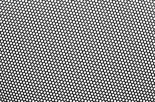 Black metal lattice with round apertures on white background. Close-up.