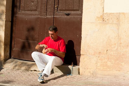 Traditional Spanish pelota player ritually wrapping his fingers in plaster protections