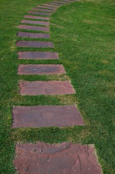 Tilled footpath on the green lawn. Tranquil natural scene.