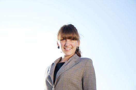 portrait of young business woman, a blue sky background