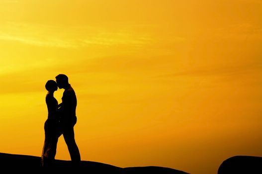 Silhouette of couple kissing in sunset