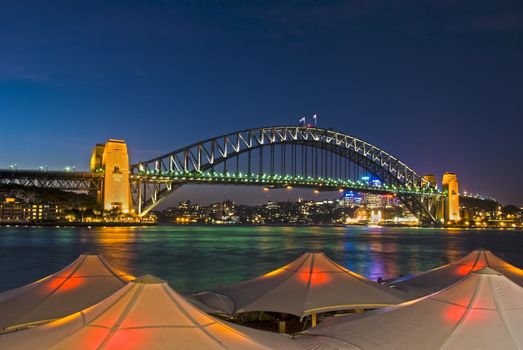 Sydney Harbour Bridge viewed from Circular Quay from behind lighted umbrellas