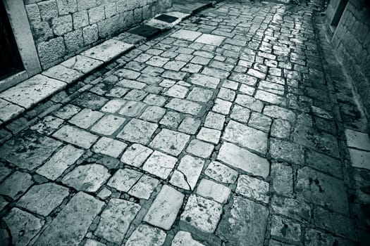 Old worn marble stone alley - Trogir, Croatia. Traces of several hundred years of daily use to be seen.