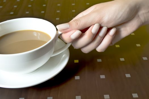 A woman holds a cup of coffee