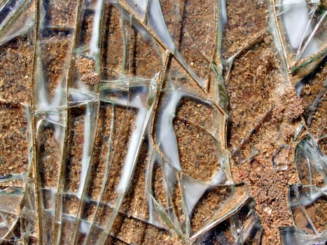 brokenned glass of the car rests upon sandy road