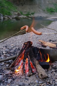 a sausage grilled on a camp fire