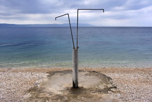 Deserted Croatian beach with shower in the summer.