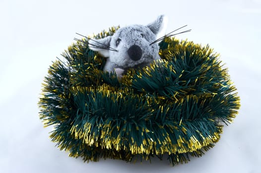 The grey toy mouse sitting in a tinsel