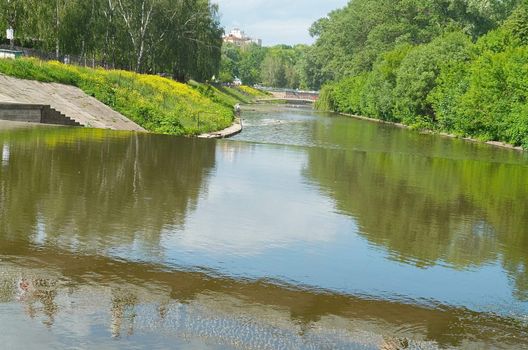 Overflow dam on small small river in city