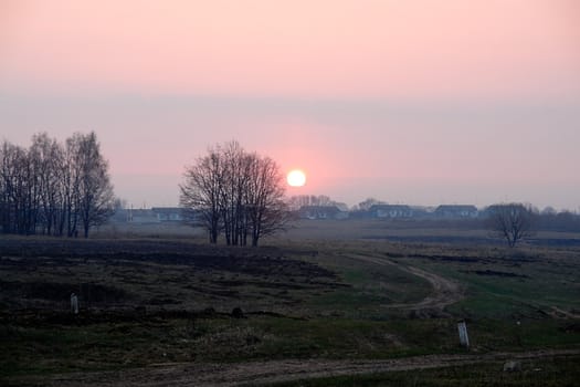 Sunrise on Russian village, a morning fog                               