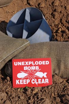 Mock unexploded bomb and sign from the Second World War, with sand bags