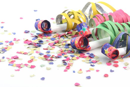party concepts  paper confetti with streamers and four party blowers on white background