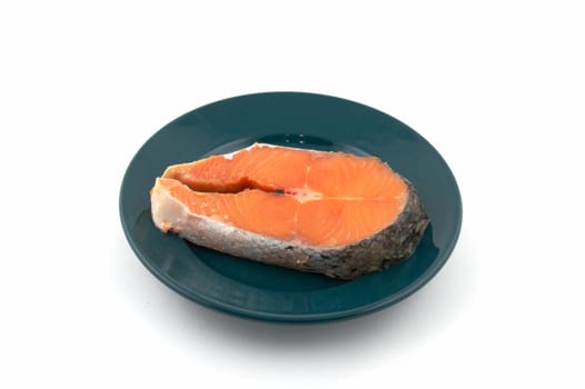 Fresh uncooked Pacific Coast Salmon on a plate of green color. 
It is not isolated, and it is photographed on a white background.