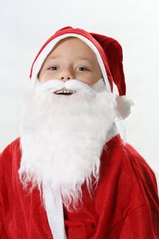 Portrait of a smiling boy in cap Santa in a white beard