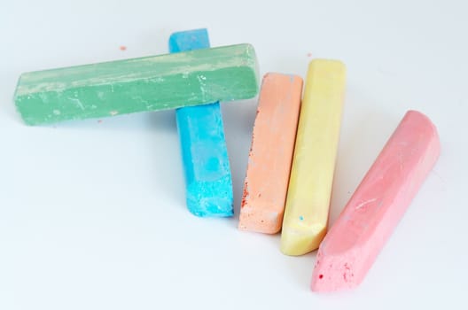 many-colored children's chalks against the white background