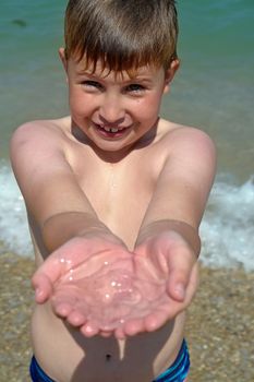 A little boy with a jellyfish on the beach