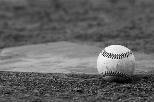 one baseball on home plate at a sports field