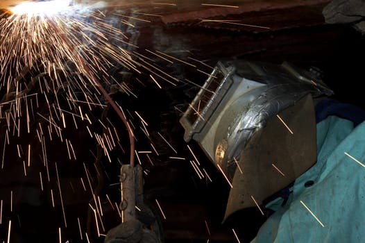 a welder working at shipyard under vessel