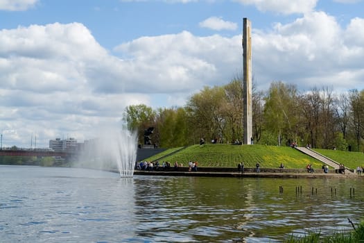 City quay with cloudy sky at background. A fountain in the river.