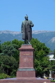 a Lenin's statue with Yalta mountains at background