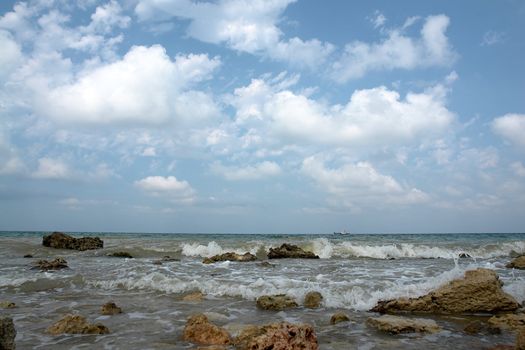 a stony seashore with cloud sky at background		