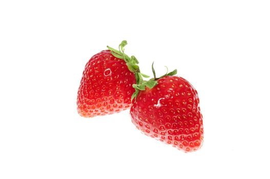 two vibrant red strawberries isolated on white