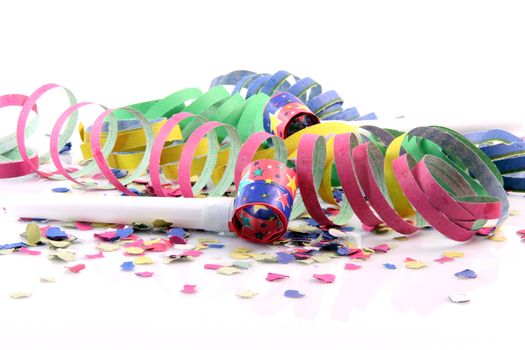 holidays and party time paper confetti with streamers and party blowers on white background