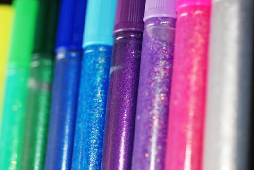A row of sparkling glitter glue pens
