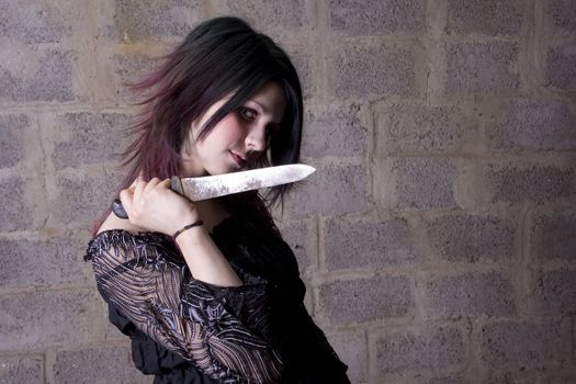 The girl in Gothic style holds the big knife