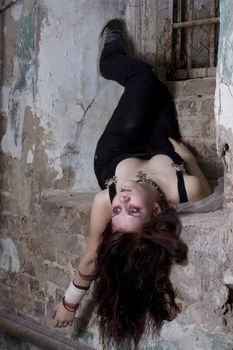 The girl lays on a back in a dirty cellar