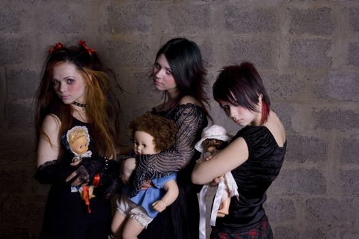 Sad, gloomy girls hold in hands of dolls