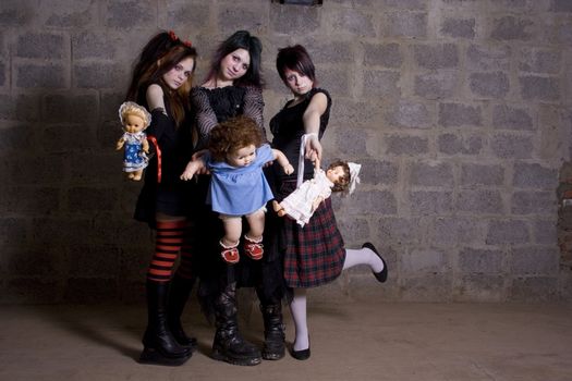 Sad, gloomy girls hold in hands of dolls