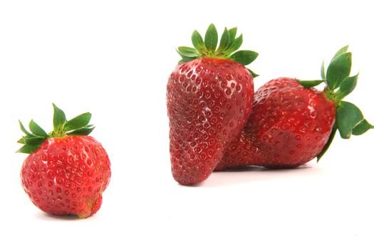 two big and one small strawberry focus on left one isolated on white background fruits and vegetables