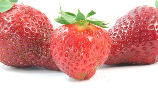 three strawberries focus on ceter one isolated on white background  fruits and vegetables
