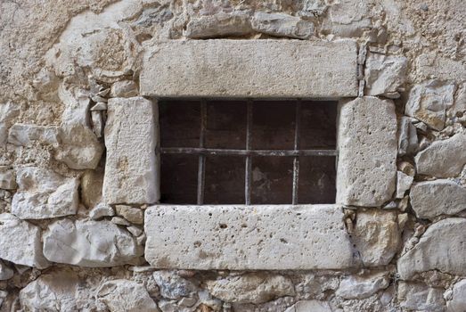 Secured window in weathered medieval stone house - Croatia.